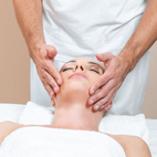 Handsome therapist doing face massage in spa room